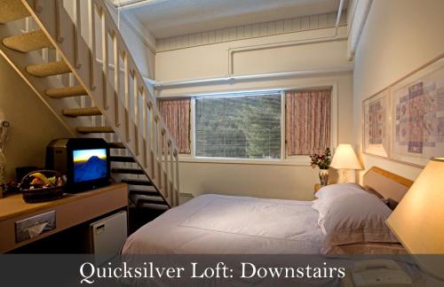 um pequeno quarto com uma cama e uma escada em Crystal Mountain Hotels em Crystal Mountain