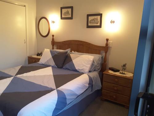 a bedroom with a bed and a dresser and a mirror at Beach B&B in Waihi Beach
