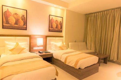 a hotel room with two beds and a window at Sangai Continental (The Boutique Hotel) in Imphal
