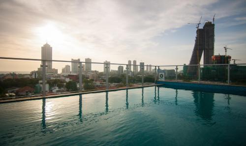 a swimming pool with a city skyline in the background at Rococo Residence in Colombo