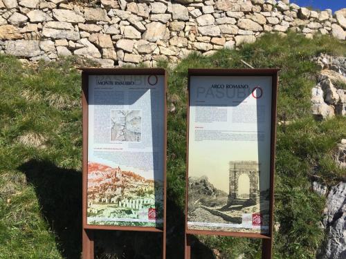 two interpretive signs in front of a stone wall at B&B Casabasoti in Valli del Pasubio