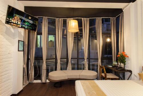 
a room with a bed, a chair, and a window at Luxury Backpakers Hotel in Hanoi
