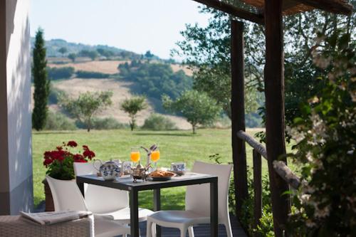 a table with wine glasses and chairs on a porch at Tenuta Di Canonica in Todi