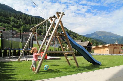 a little girl playing on a swing set at Apart Alpinlive in Ladis