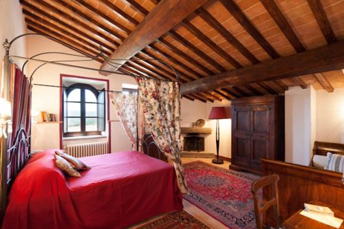 a bedroom with a red bed in a room at Tenuta Di Canonica in Todi