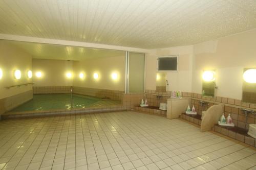 a large bathroom with a swimming pool in the middle at Kagetsuen in Hakone