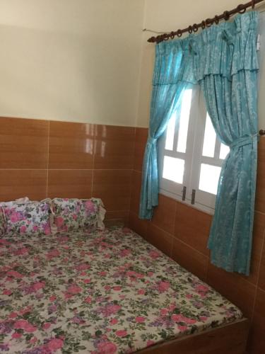 a bedroom with a bed and a window at Nhu Y Guesthouse in Phan Rang–Tháp Chàm