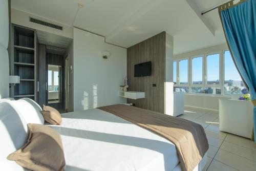 a bedroom with a large bed and a television at Hotel Cristallo in Riccione