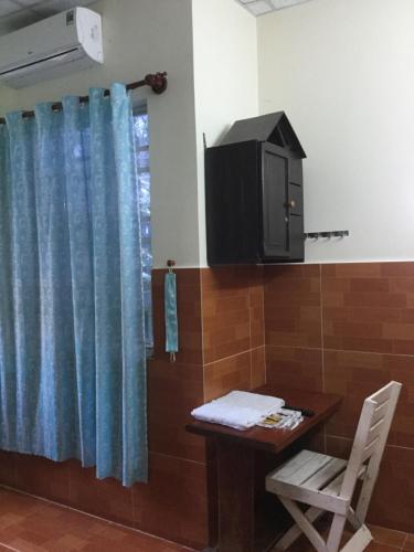 a room with a table and a television and a table and chair at Nhu Y Guesthouse in Phan Rang–Tháp Chàm