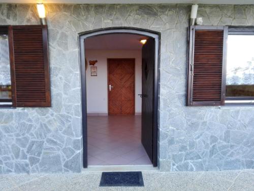 a door to a house with a stone wall at Getaway "At the three lights" in Sevnica