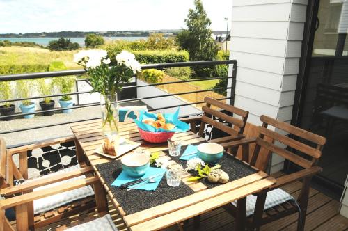 - une table avec deux chaises sur une terrasse couverte avec une table dans l'établissement le Ti'Nid - Gîte de charme - Vue Mer, à Langueux