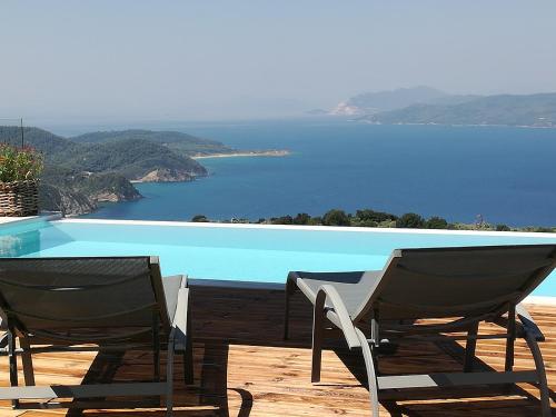 a pair of chairs sitting next to a swimming pool at Luxury Villa in Kechria 2 in Kechria