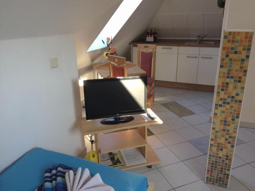 a living room with a tv and a kitchen at Ferienwohnungen Rehn in Dresden
