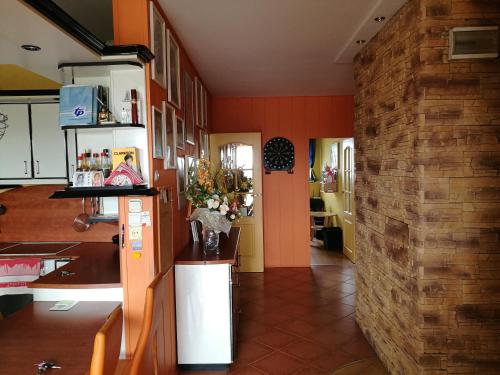 シフィノウイシチェにあるApartament Milaのオレンジ色の壁とレンガの壁のキッチン