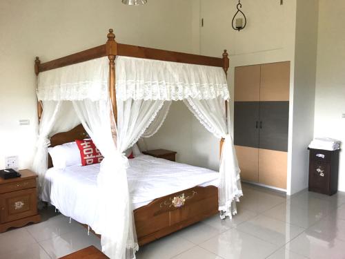 a bedroom with a canopy bed with white curtains at Yin Mama Warm House in Yilan City