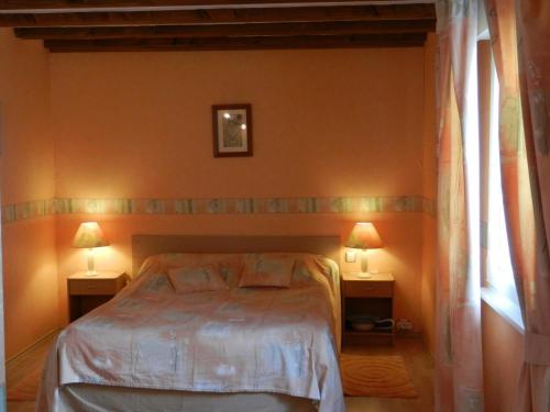 a bedroom with a bed and two lamps on two tables at Chambres d'hôtes Chez Dany in Gerstheim