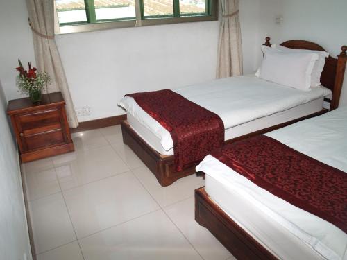 a hotel room with two beds and a window at Evergreen Hotel in Antananarivo