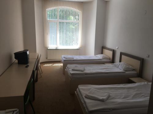 a room with three beds and a window at Hostel Elena in Sofia