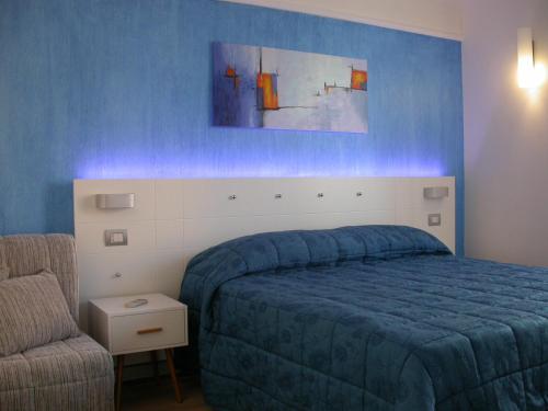 ein Schlafzimmer mit einem blauen Bett und einem Stuhl in der Unterkunft Bed & Breakfast Palazzo Ducale in Andria