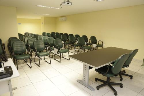a room with a row of chairs and a table at LW Hotel in Arcoverde