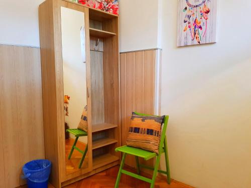 a room with two green chairs and a mirror at Crazy House Hostel in Pula