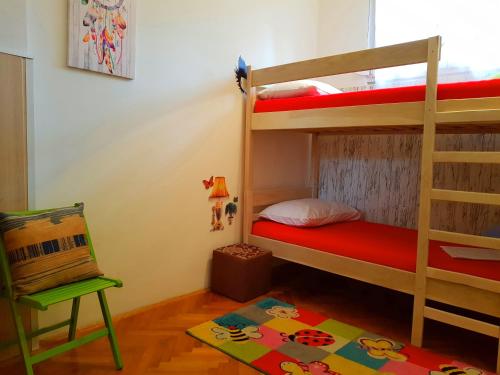 a bedroom with bunk beds and a chair and a rug at Crazy House Hostel in Pula