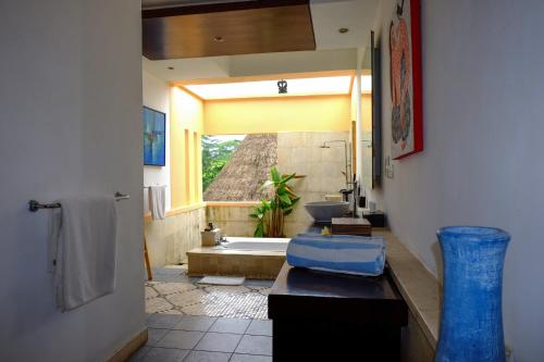 a bathroom with a tub and a sink and a window at Villa Sebali in Ubud