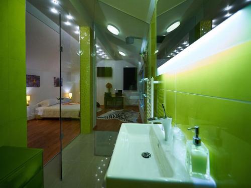 a green bathroom with a sink and a bedroom at Villa Maranata-5 stars-pool-spa-gym-free parking-privacy in Jesenice
