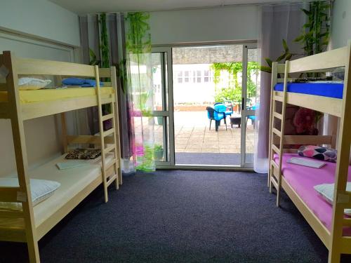 a room with bunk beds and a door to a patio at Crazy House Hostel in Pula
