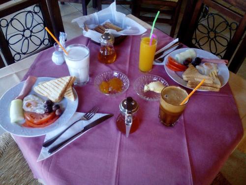 a purple table topped with plates of food and drinks at Thea Dodoni in Manteio