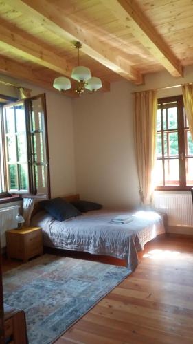 sypialnia z łóżkiem w pokoju z oknami w obiekcie Ropki Dwór RAJDANY w mieście Ropki