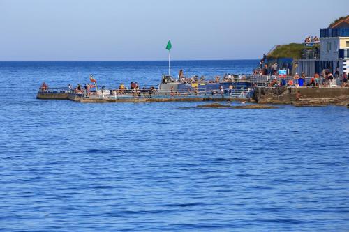 a group of people on a pier in the water at Devoncourt Devoncoast SeaView Apartments in Brixham