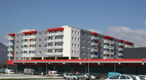 a large building with cars parked in a parking lot at Sarajevo Apartment Ilidza in Sarajevo