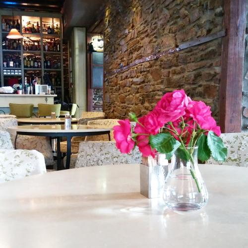 a vase with pink flowers sitting on a table at Marelia Hotel in Poligiros