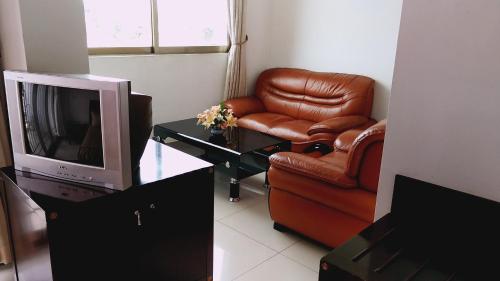 sala de estar con silla y TV en Evergreen Hotel en Antananarivo