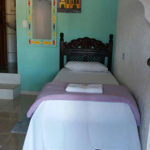 a bedroom with a bed with purple sheets and a mirror at SunriseBelaVista Pousada e Flats in Paraty