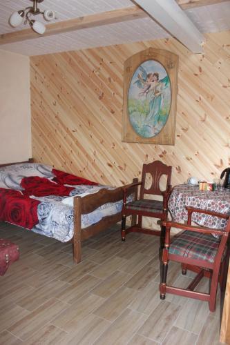 a room with two beds and a chair in it at Vilkdvaris in Plungė