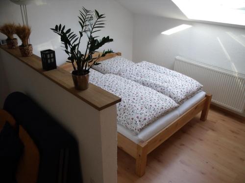 - un petit lit dans une chambre avec une plante en pot dans l'établissement Wasserwerk Trachau, à Dresde