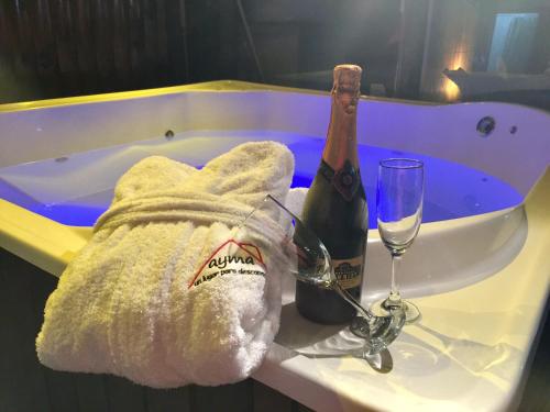 a bath tub with a bottle of champagne and a glass at Ayma in Chascomús