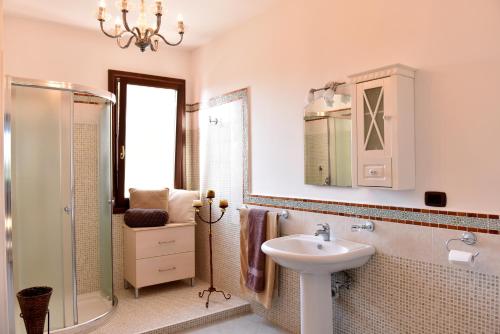 łazienka z umywalką i prysznicem oraz lustrem w obiekcie B&B Villa Anastasia Club w mieście Mesagne