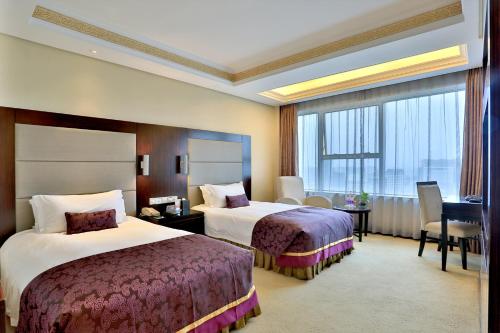 Postel nebo postele na pokoji v ubytování Yi Mei Plaza Hotel