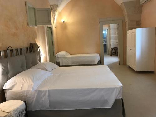 1 dormitorio con 2 camas y nevera en Tenuta Castelle, en Cutrofiano