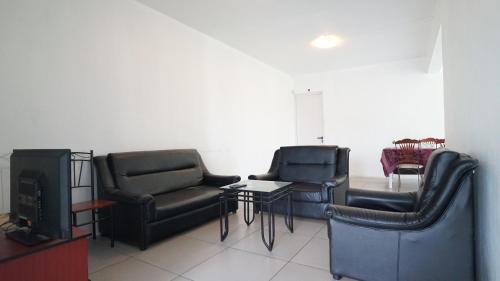 a living room with two chairs and a tv at La Dorade in Trou aux Biches