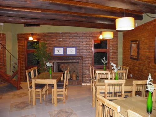 comedor con mesas y sillas de madera y chimenea en Posada de campo Mamúll Mapú, en Rancul
