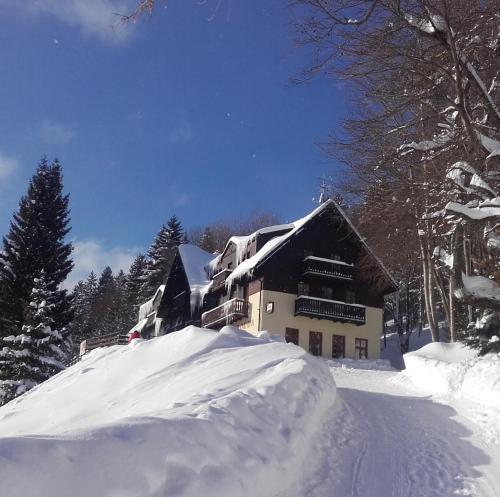 a house in the snow with a pile of snow at Svycarska Bouda in Špindlerův Mlýn