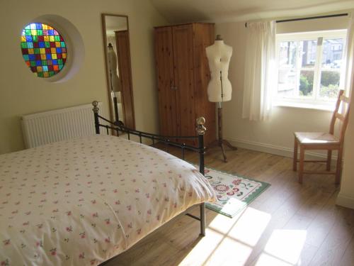 a bedroom with a bed and a dresser and a window at Carpenter's Cottage in Pocklington