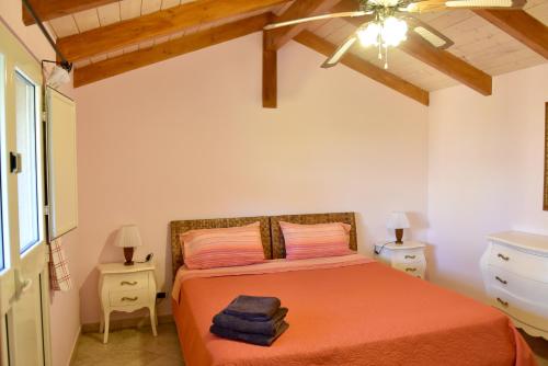 sypialnia z łóżkiem z pomarańczową pościelą i drewnianymi sufitami w obiekcie B&B Villa Anastasia Club w mieście Mesagne