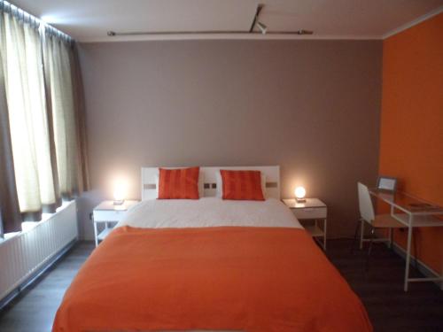 a bedroom with a large orange bed with two lamps at Suite 11 in Antwerp