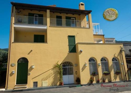 a yellow building with a clock on top of it at B&B Villa I Nobili in Cava deʼ Tirreni