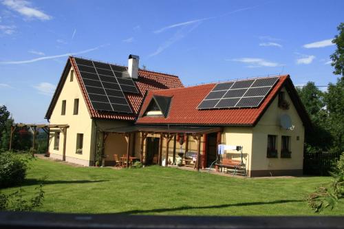 a house with solar panels on the roof at Taneček - malý apartmán u rodinného domu in Stvolínky